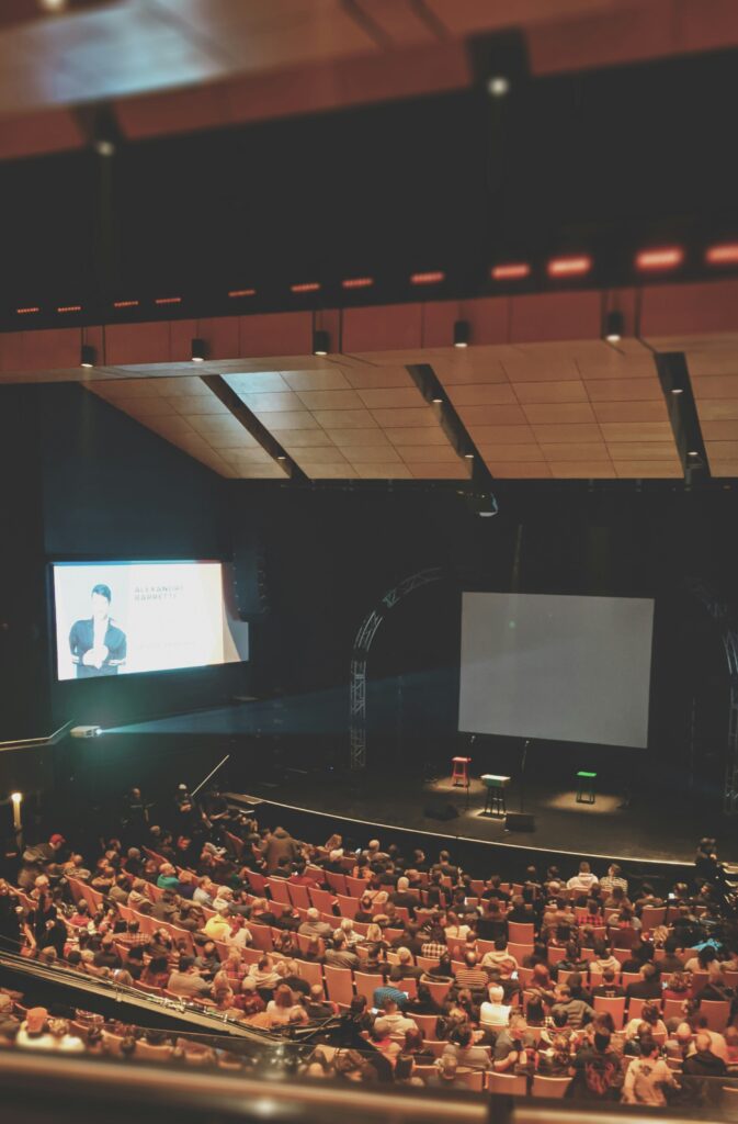 group of people in auditorium viewing presentation on screen